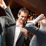 Lawyers drinking shots with one man looking disturbed Lawyers drinking shots with one man looking disturbed