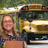 Stephanie Langer standing with a file in front of a school bus in a home made photoshopped picture