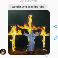 text of picture of man in white KKK robes infront of three burning crosses, with "I wonder who is in this robe? in a text above the picture text of picture of man in white KKK robes infront of three burning crosses, with "I wonder who is in this robe? in a text above the picture