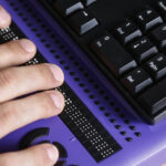 Braille Purple Keyboard with hands on it for Voting
