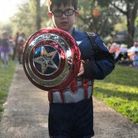 a child dressed in a captain america uniform with a shield.