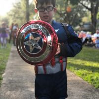 a child dressed in a captain america uniform with a shield. a child dressed in a captain america uniform with a shield.