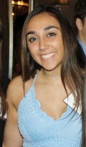 head shot of Sabrina smiling and wearing a blue dress.