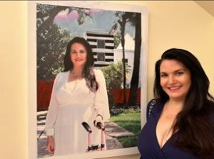 Justine smiling in front of a picture of herself