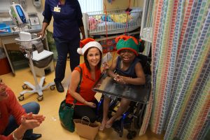Rachel and a little boy in a wheelchair smiling at the camera