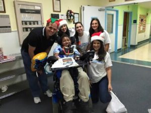 DIG staff with a young man in a wheelchair wearing christmas hats