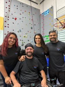 a person with a disability rock climbing with his friends