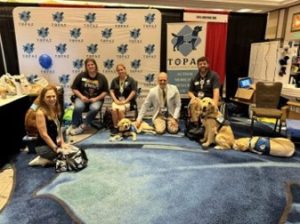 Debbie and Matt sitting with Dogs from the Topaz dog school