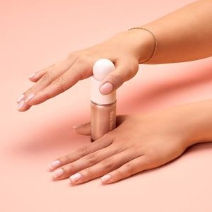 2 hands holding the top of a bottle of make up