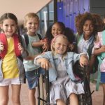 a group of elementary students with and without disabilities in a school hallway