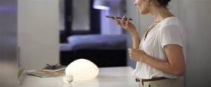 voice activated light the woman is using her phone to turn on a light